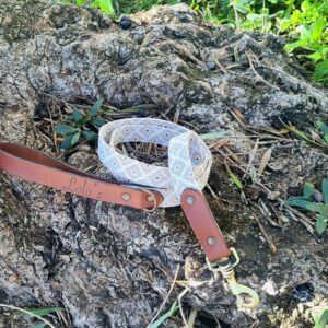 Correa y collar de tejido Coffee de LOLO'S sobre una roca cubierta de musgo